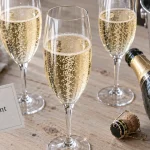 Vin pétillant : verres tulipe avec bulles sur table en bois